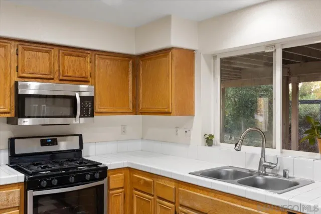a kitchen with granite countertop a sink stainless steel appliances and cabinets