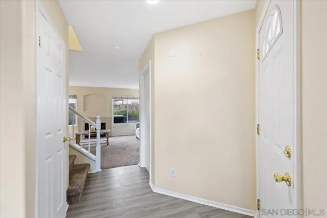 a hallway with wooden floor fireplace and living room