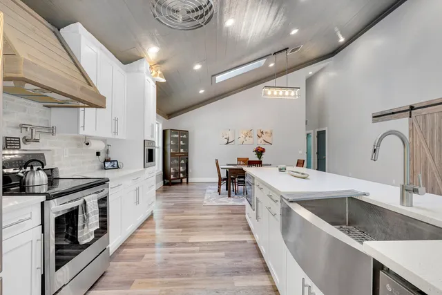 a large kitchen with stainless steel appliances lots of counter space and a sink