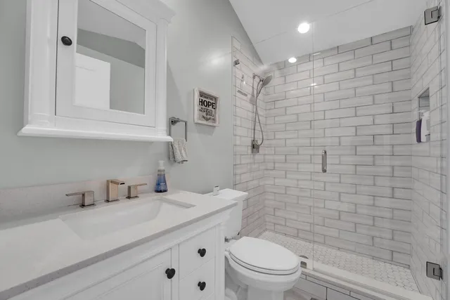 a bathroom with a sink a toilet and shower