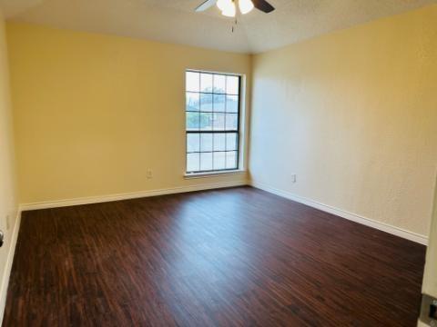 205 Apollo Road Garland, TX 75040 - Photo 3 of 6 a view of an empty room with wooden floor and a window