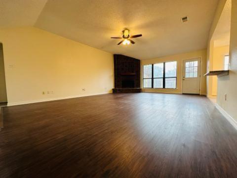 205 Apollo Road Garland, TX 75040 - Photo 6 of 6 a view of an empty room with wooden floor and a window
