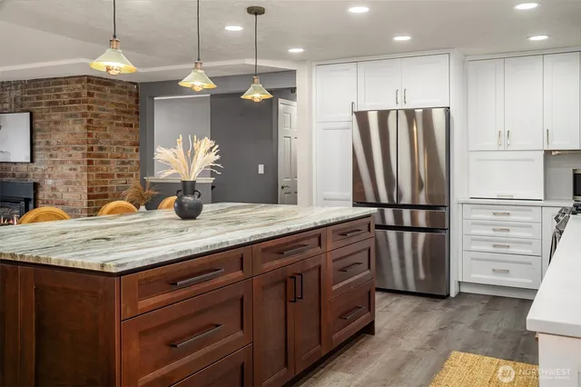 a kitchen with stainless steel appliances granite countertop a refrigerator a sink and a stove