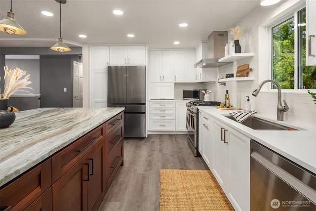a kitchen with a sink a counter top space stainless steel appliances and a window