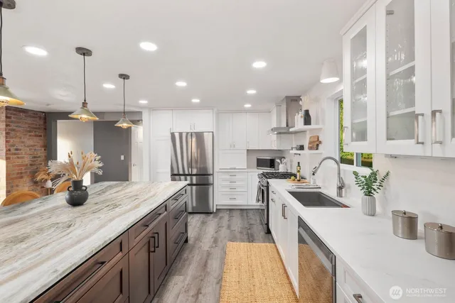 a kitchen with a sink stainless steel appliances and white cabinets