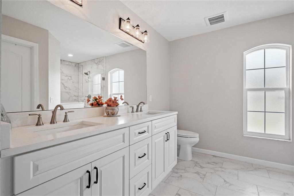 12929 Southwest 89th Street Dunnellon, FL 34432 - Photo 3 of 76 a bathroom with a double vanity sink toilet and a mirror