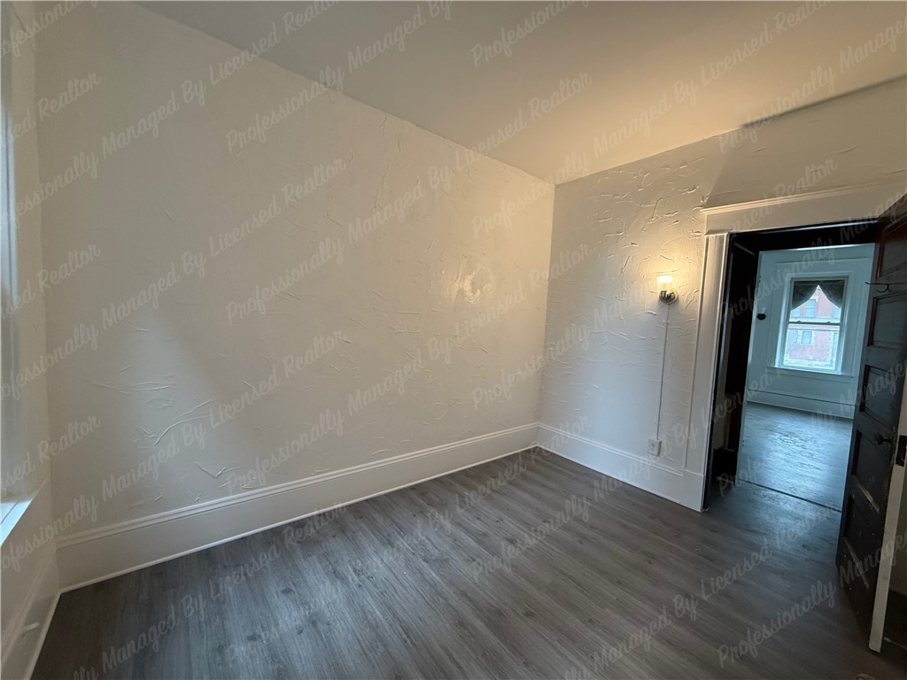 44 West High Street, Unit B Springfield, OH 45502 - Photo 18 of 31 This cozy bedroom features durable flooring, offering a comfortable and practical living space.