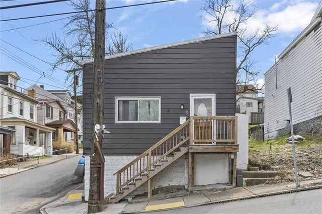 a front view of a house with iron stairs
