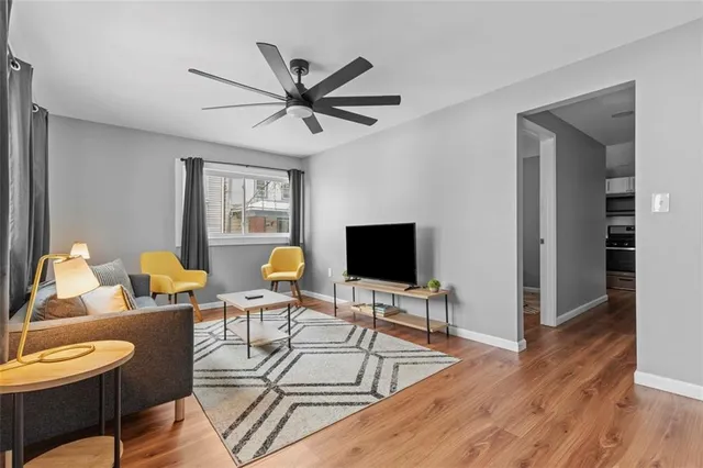 a living room with furniture a flat screen tv and a window