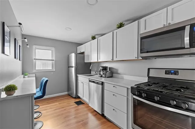 a kitchen with stainless steel appliances a stove microwave and sink