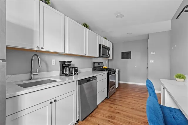 a kitchen with kitchen island granite countertop a sink and wooden cabinets