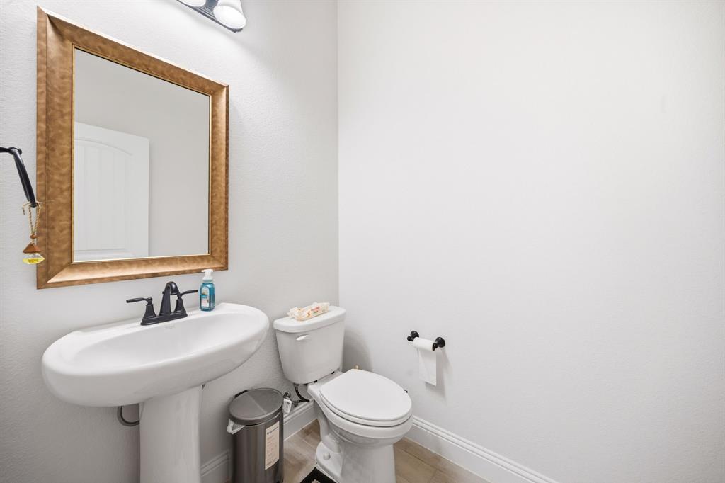 3841 Eagles Bluff Road Midlothian, TX 76065 - Photo 6 of 36 a bathroom with a toilet a sink and mirror