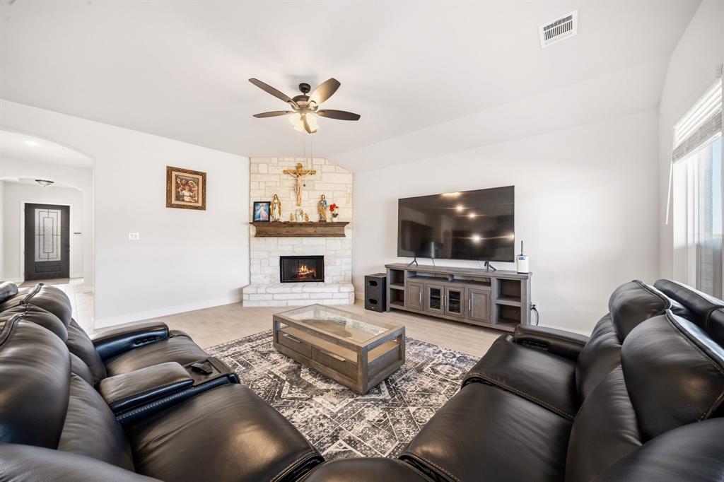 3841 Eagles Bluff Road Midlothian, TX 76065 - Photo 10 of 36 a living room with furniture a flat screen tv and a fireplace