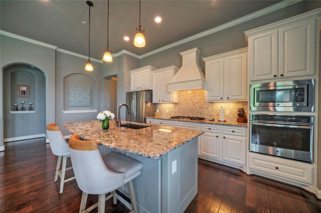 101 Maxwell Way Austin, TX 78738 - Photo 15 of 40 a kitchen with stainless steel appliances granite countertop a stove a sink and a microwave