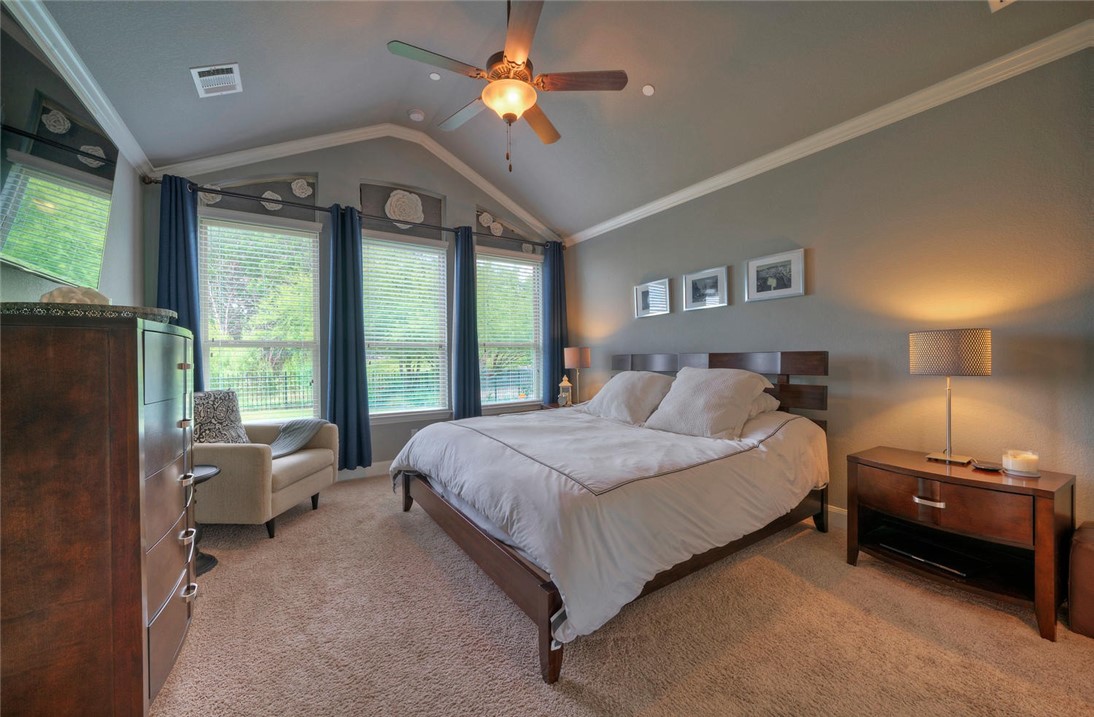 101 Maxwell Way Austin, TX 78738 - Photo 20 of 40 a spacious bedroom with a bed couch and a large window