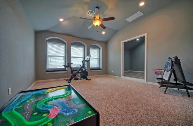 a room with pool table gym equipment wooden floor and a chandelier