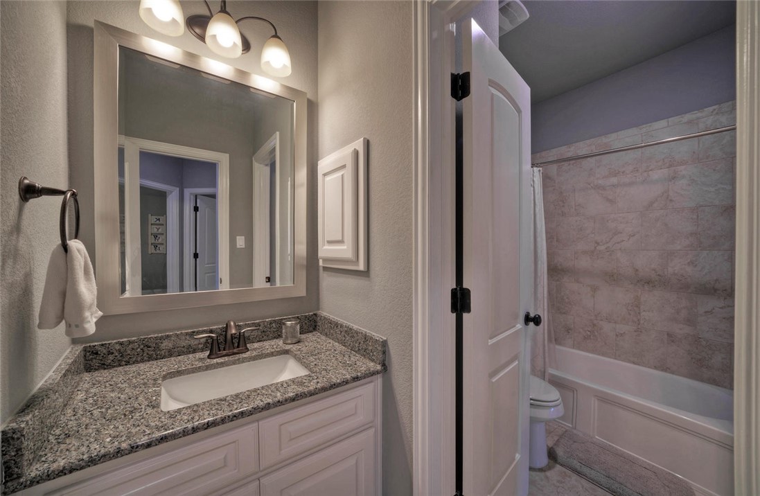 101 Maxwell Way Austin, TX 78738 - Photo 33 of 40 a bathroom with a granite countertop sink a toilet and shower