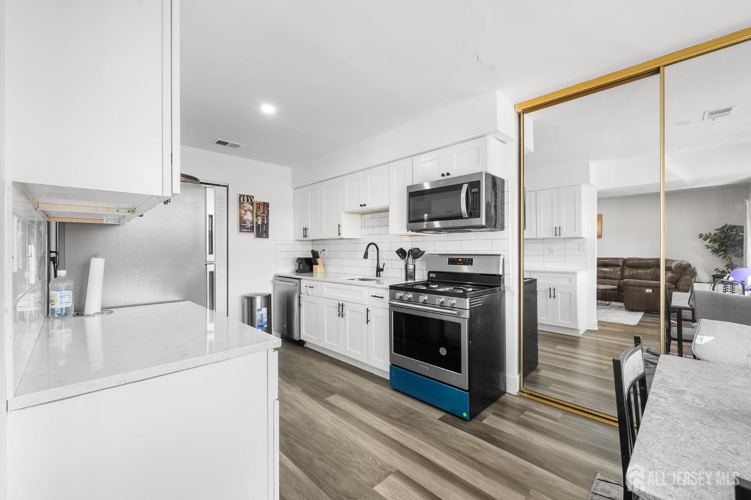 1609 Raspberry Court Edison, NJ 08817 - Photo 10 of 18 a kitchen with stainless steel appliances a stove top oven a sink and a refrigerator