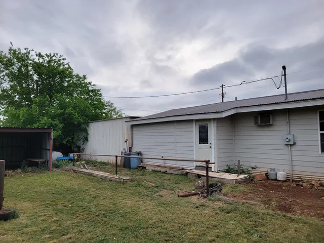 a backyard of a house with table and chairs