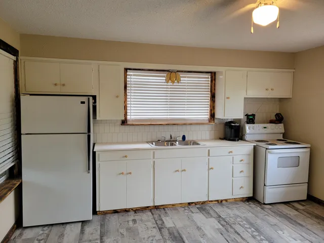a kitchen with a white cabinets and white appliances