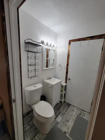 a white toilet sitting next to a bathroom sink and vanity