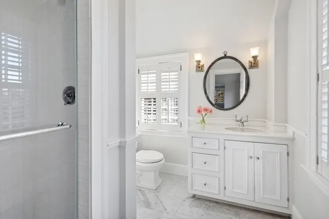 a bathroom with a granite countertop sink and a window