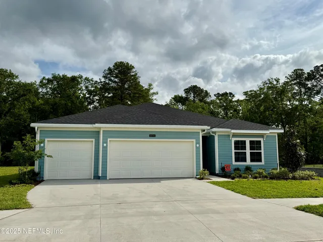 front view of a house with a yard and trees