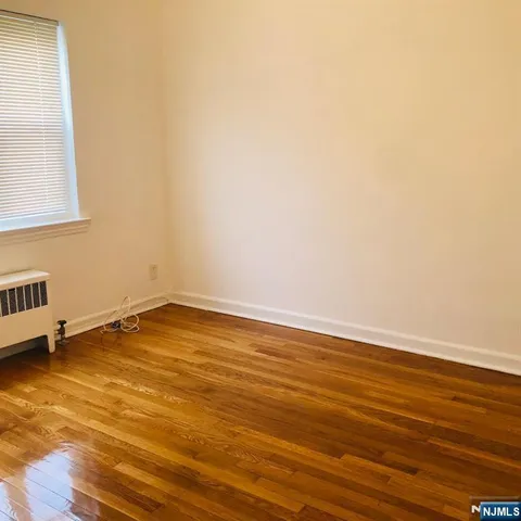 an empty room with wooden floor and a window