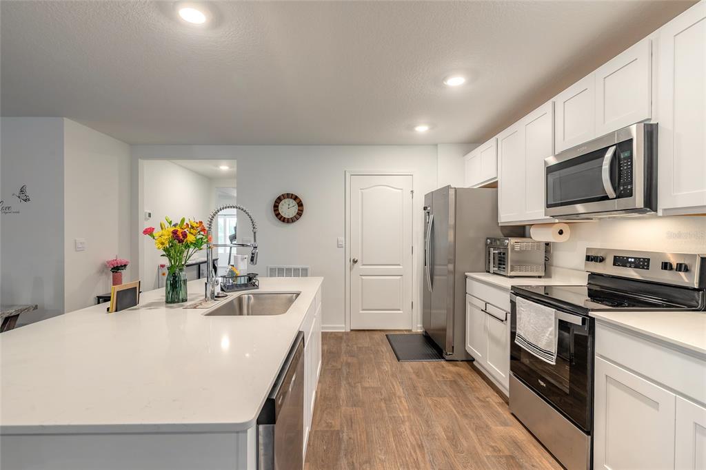 82 Hulett Wds Road Palm Coast, FL 32137 - Photo 9 of 48 a kitchen with stainless steel appliances a stove sink microwave refrigerator and cabinets