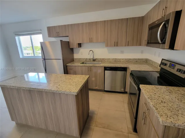 a kitchen with stainless steel appliances granite countertop a sink counter space and cabinets