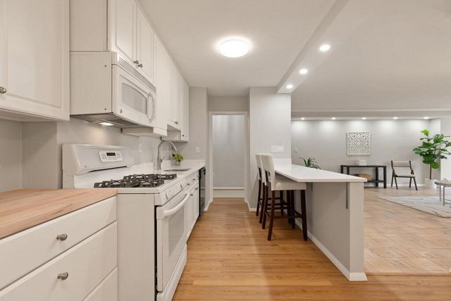 a kitchen with cabinets and wooden floor
