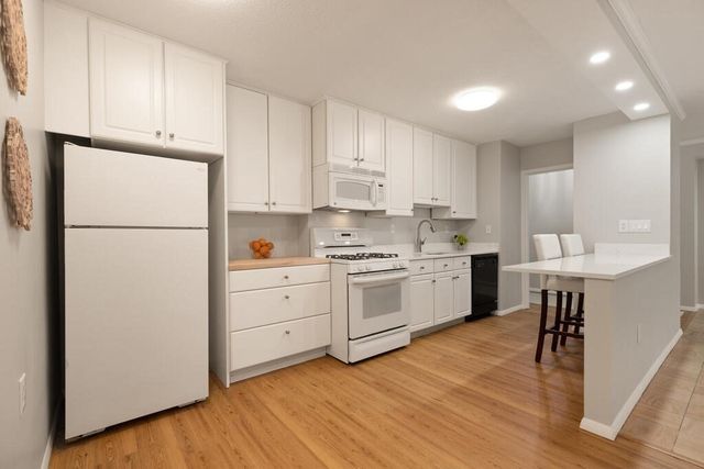 a kitchen with white cabinets and white appliances