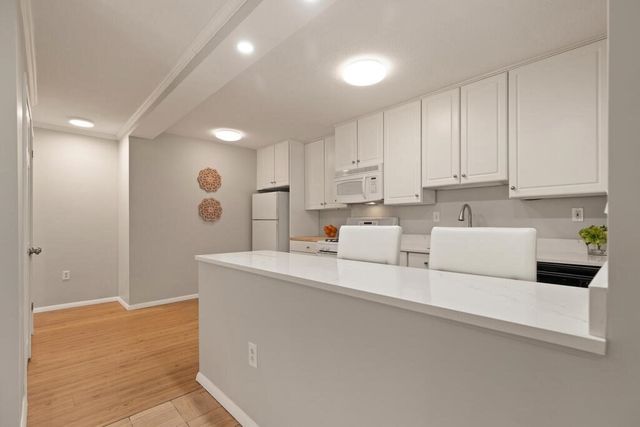 a view of kitchen with white cabinets