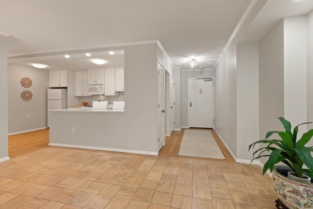 a view of a kitchen with refrigerator and white walls