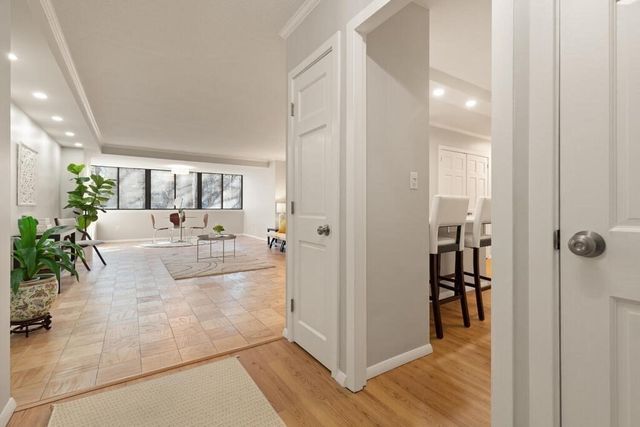 a view of a hallway with wooden floor and living room