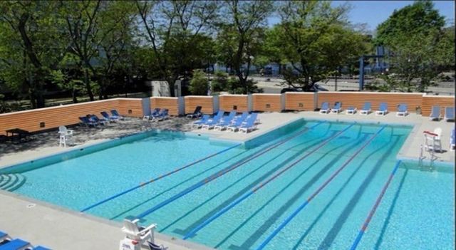 swimming pool view with a seating space