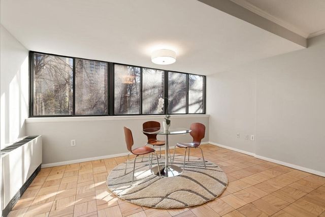 a dining room with wooden floor and windows
