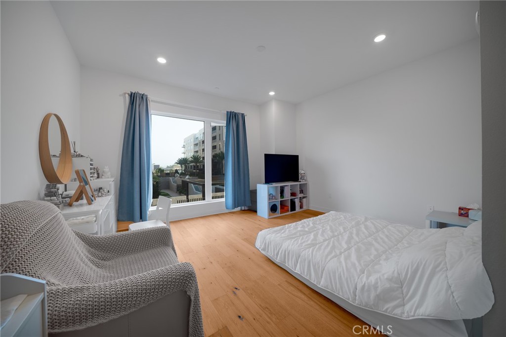 1310 Rivington Irvine, CA 92612 - Photo 11 of 20 a bedroom with a bed a couch and a flat tv screen on the dresser