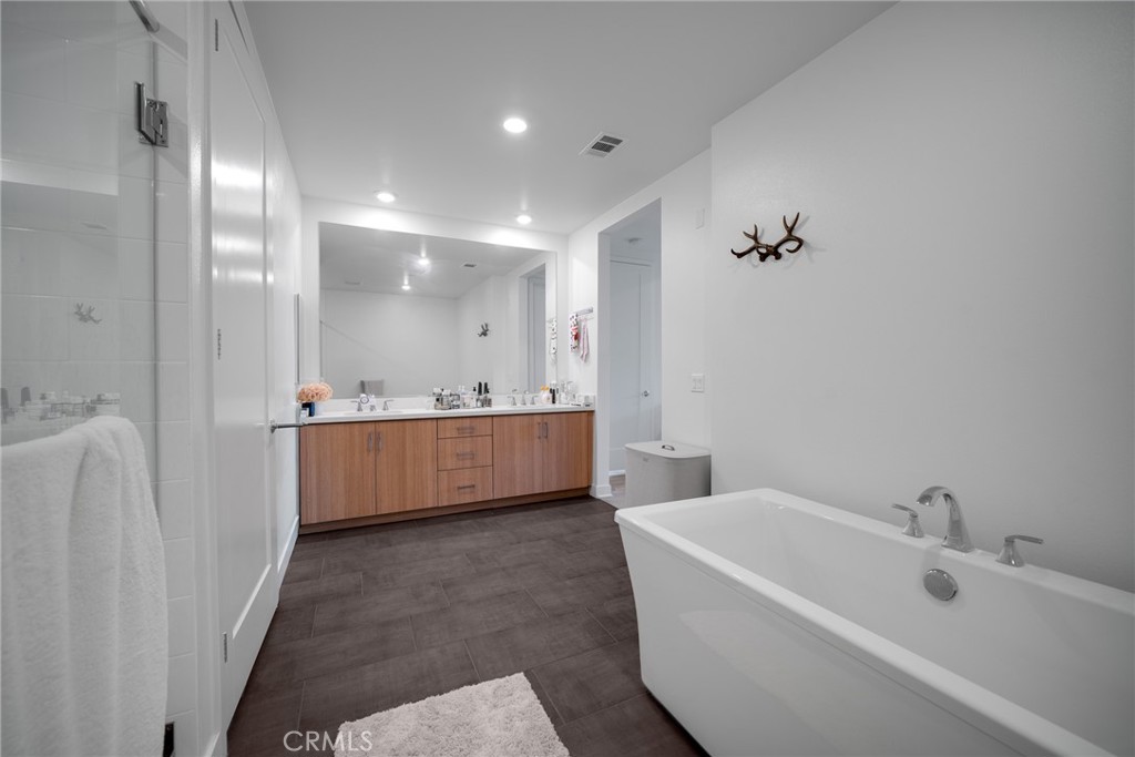 1310 Rivington Irvine, CA 92612 - Photo 14 of 20 a bathroom with a bathtub a mirror a sink and vanity