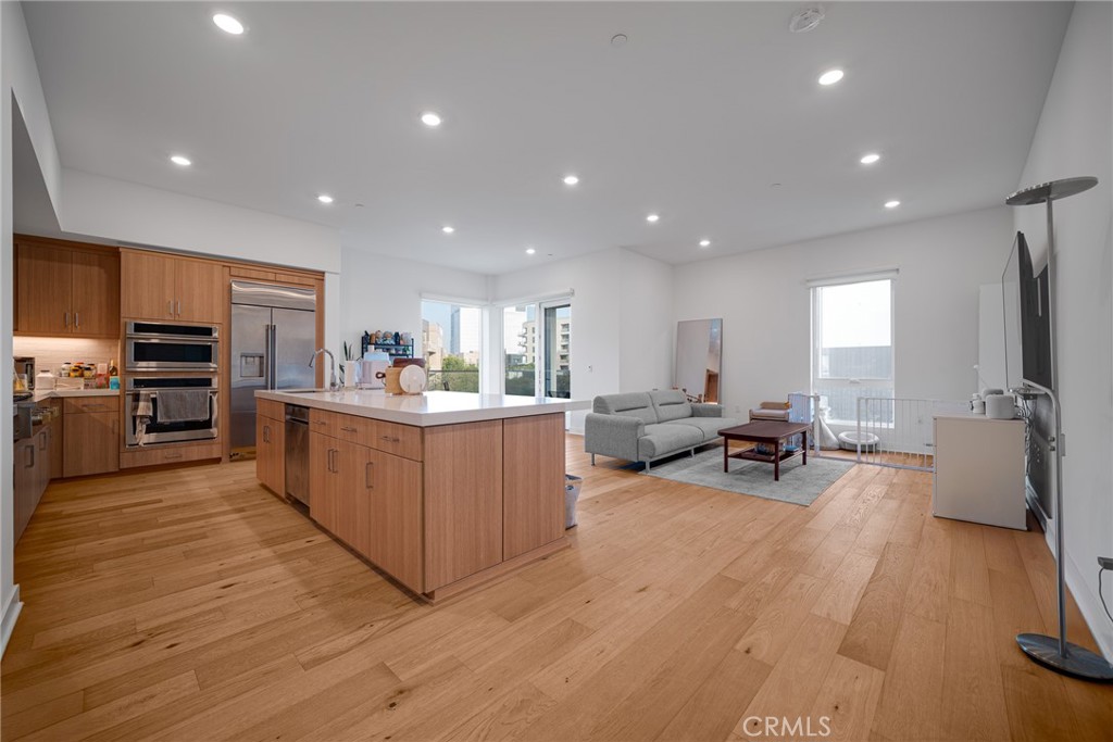1310 Rivington Irvine, CA 92612 - Photo 6 of 20 a large kitchen with stainless steel appliances granite countertop a large counter top a couch and a view of living room