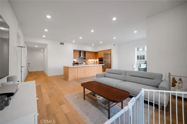 a living room with furniture and a dining table with wooden floor