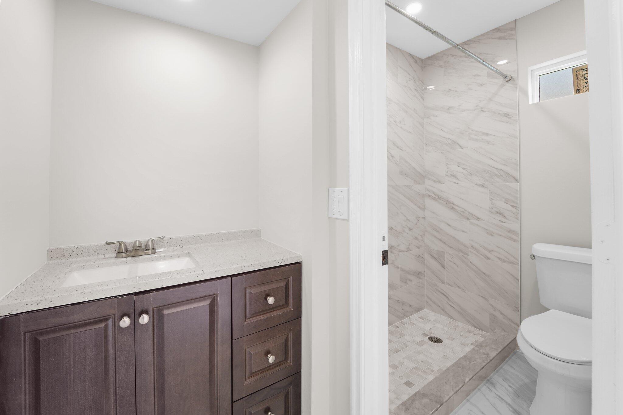 22207 Alyssum Way Boca Raton, FL 33433 - Photo 18 of 31 a bathroom with a granite countertop sink toilet and shower