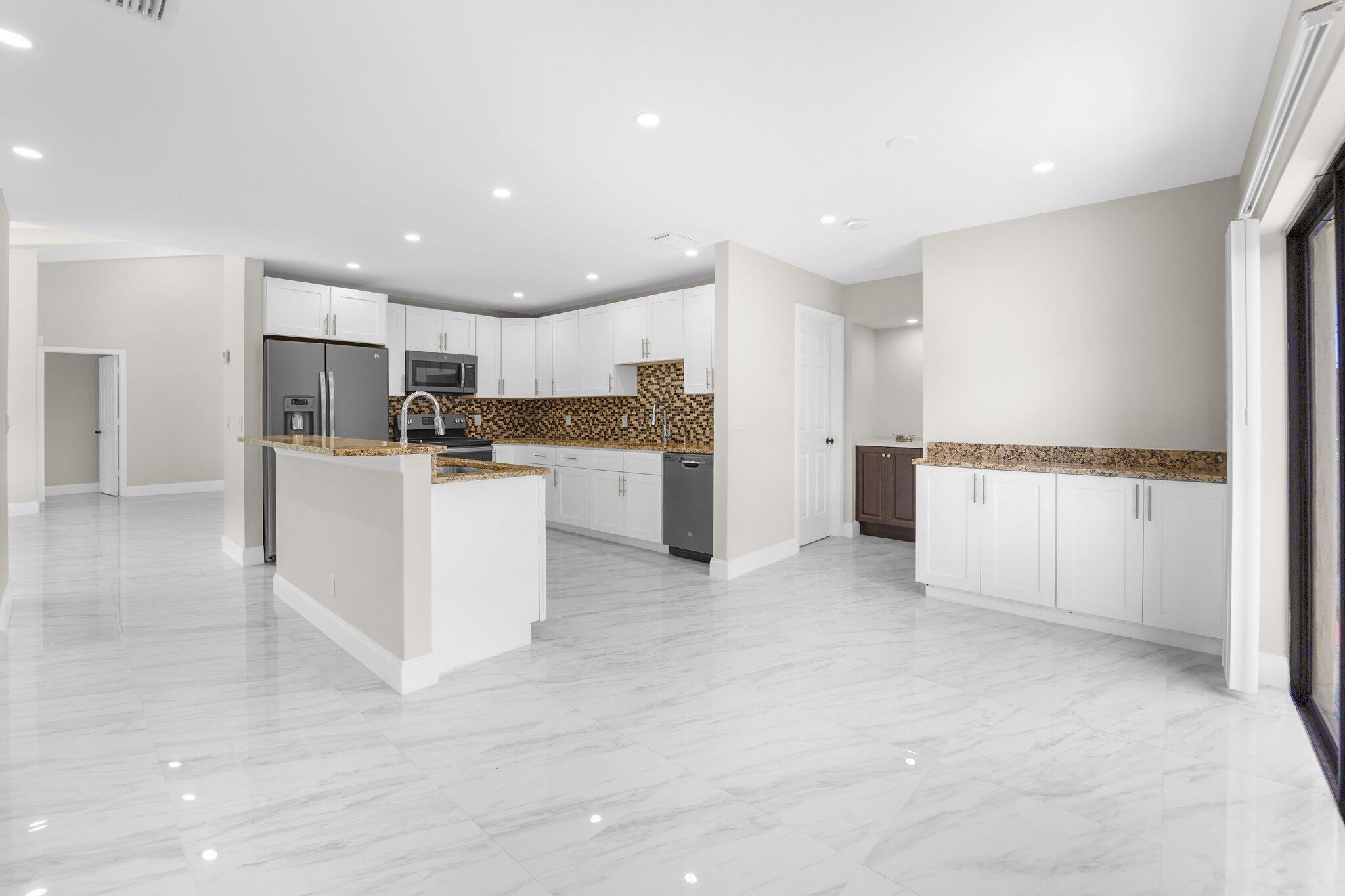 22207 Alyssum Way Boca Raton, FL 33433 - Photo 5 of 31 a kitchen with stainless steel appliances granite countertop a refrigerator and a stove top oven