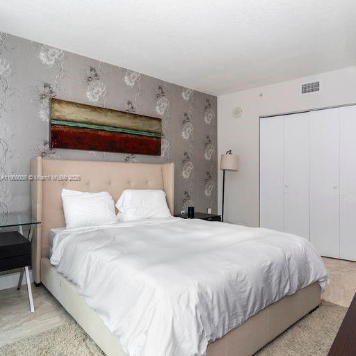 200 Sunny Isles Boulevard, Unit 2604 Sunny Isles Beach, FL 33160 - Photo 13 of 36 a bedroom with a bed and a closet