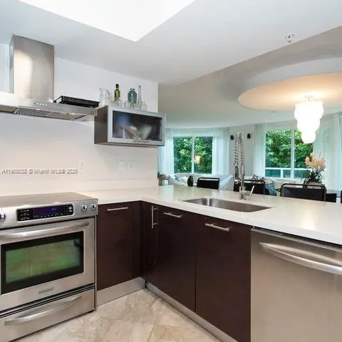 a kitchen with stainless steel appliances a stove a sink and a microwave