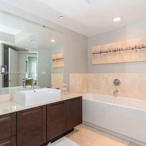 200 Sunny Isles Boulevard, Unit 2604 Sunny Isles Beach, FL 33160 - Photo 26 of 36 a bathroom with a double vanity sink mirror and bathtub