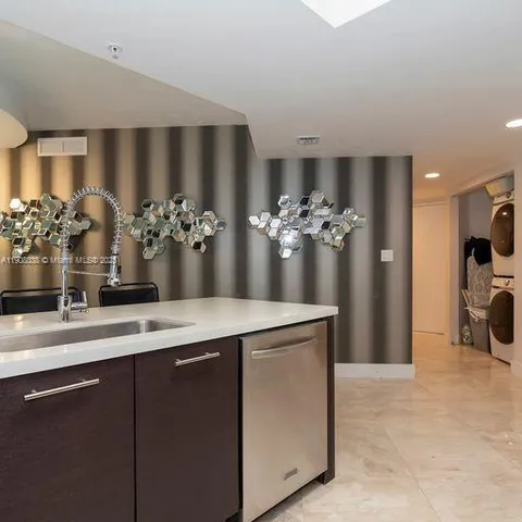 a view of a kitchen with a sink and a refrigerator