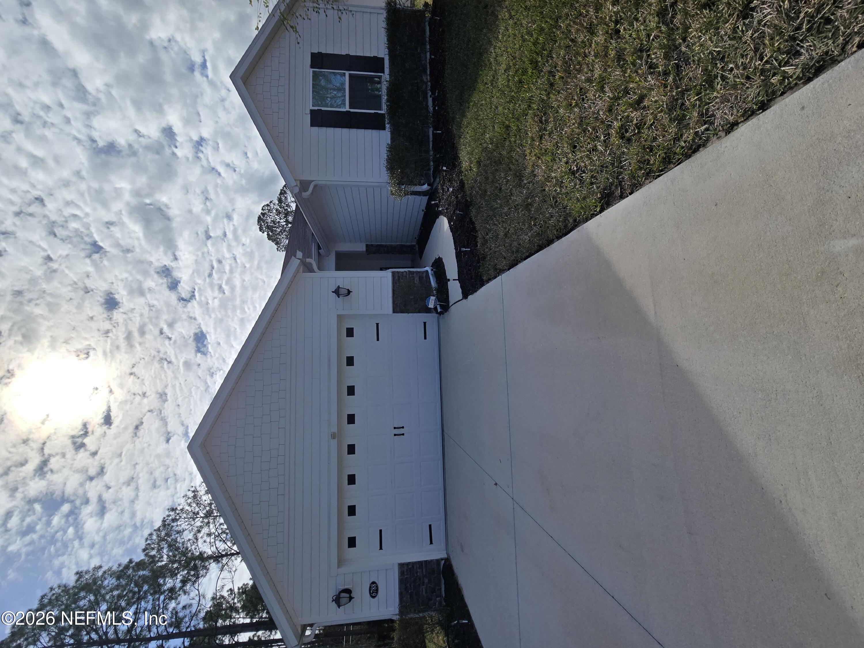 a backyard of a house with dishwasher and wooden fence