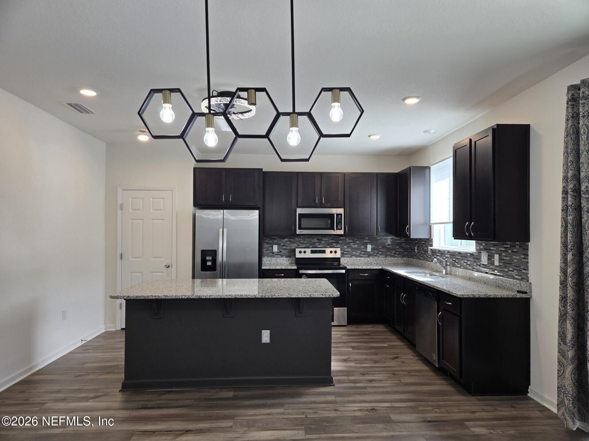 6788 Burnt Crk Road Jacksonville, FL 32222 - Photo 15 of 25 a kitchen with cabinets wooden floor and stainless steel appliances