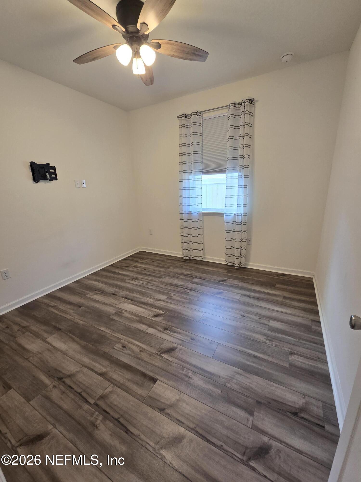 6788 Burnt Crk Road Jacksonville, FL 32222 - Photo 5 of 25 wooden floor in an empty room with a window